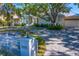Charming two-story home with lush landscaping, a circular driveway and white picket fence with address marker at 1695 Brightwaters Ne Blvd, St Petersburg, FL 33704