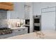 Modern kitchen featuring stainless steel appliances, gray cabinetry, and marble countertops at 1695 Brightwaters Ne Blvd, St Petersburg, FL 33704
