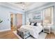 A well lit main bedroom features a sliding barn door, white linens and elegant decor at 1695 Brightwaters Ne Blvd, St Petersburg, FL 33704