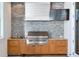 State-of-the-art outdoor grill featuring wood cabinets and a stainless steel hood for elevated outdoor cooking at 1695 Brightwaters Ne Blvd, St Petersburg, FL 33704