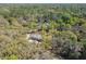 A home with a gray roof and tan siding sits nestled among mature oak trees at 17913 Greensboro St, Spring Hill, FL 34610
