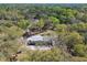A home with a gray roof and tan siding nestled among mature oak trees at 17913 Greensboro St, Spring Hill, FL 34610