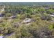 A home with a gray roof and tan siding sits nestled among mature oak trees at 17913 Greensboro St, Spring Hill, FL 34610