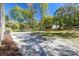 Large backyard with mature trees, a grassy lawn, and a storage building, offering endless possibilities for outdoor living at 17913 Greensboro St, Spring Hill, FL 34610