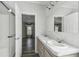 Bathroom with dual sinks and a separate shower in a neutral color palette with an open doorway at 17913 Greensboro St, Spring Hill, FL 34610