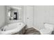 Bathroom with a standalone tub, toilet, vanity mirror, and neutral walls and floors at 17913 Greensboro St, Spring Hill, FL 34610