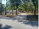 Inviting single-story home with a gravel driveway surrounded by mature trees, offering a serene and private setting at 17913 Greensboro St, Spring Hill, FL 34610