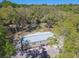 An angled aerial view showing this home's exterior, surrounding yard and wooded neighborhood at 17913 Greensboro St, Spring Hill, FL 34610