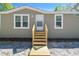 Close-up of the front entrance, highlighting the exterior details and the wooden steps leading to the front door at 17913 Greensboro St, Spring Hill, FL 34610