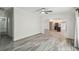 Open-concept living room with wood-look floors flowing into kitchen featuring a center island and stainless steel appliances at 17913 Greensboro St, Spring Hill, FL 34610