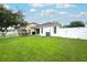 Expansive backyard with lush green grass, white fence, and a covered patio for outdoor enjoyment at 18150 Leamington Ln, Land O Lakes, FL 34638