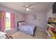 Charming bedroom painted in lovely lavender, featuring decor, comfortable bed and bright natural light at 18150 Leamington Ln, Land O Lakes, FL 34638