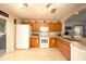 Charming kitchen with wood cabinets, tile floor, and white appliances at 18150 Leamington Ln, Land O Lakes, FL 34638