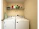 Functional laundry room featuring a washer, dryer, and shelving for convenient storage and organization at 18150 Leamington Ln, Land O Lakes, FL 34638