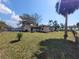 Spacious backyard with partial fence, mature trees, and a glimpse of the surrounding neighborhood at 204 Shore W Dr, Oldsmar, FL 34677