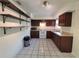 Functional kitchen with wood cabinets, white appliances, and durable tile flooring at 204 Shore W Dr, Oldsmar, FL 34677