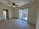 Neutral living room featuring tile flooring, ceiling fan, and sliding glass doors to backyard at 204 Shore W Dr, Oldsmar, FL 34677