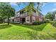 View of the building's rear facade with a screened balcony and green lawn at 2119 Kings Palace Dr, Riverview, FL 33578