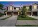 Townhome showcasing a well-manicured front yard, attached garages, and coordinated exterior color scheme at 2119 Kings Palace Dr, Riverview, FL 33578