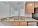 A kitchen sink and granite countertop with stainless steel appliances beneath wood cabinetry at 2119 Kings Palace Dr, Riverview, FL 33578