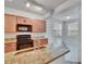 A kitchen featuring an eat-in area with modern black appliances, granite counters, and wood cabinets at 2119 Kings Palace Dr, Riverview, FL 33578