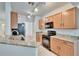 Modern kitchen featuring stainless steel appliances, granite countertops, and wood cabinetry at 2119 Kings Palace Dr, Riverview, FL 33578