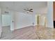 Open living room with neutral walls, wood floors, a ceiling fan, and doorways to the kitchen and bedrooms at 2119 Kings Palace Dr, Riverview, FL 33578