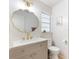 Bright bathroom boasts gold fixtures, unique vanity, and updated design, offering a stylish and functional space at 2449 Running Oak Ct, Spring Hill, FL 34608