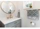Bright bathroom with marble countertop, grey vanity, and gold fixtures at 2449 Running Oak Ct, Spring Hill, FL 34608