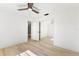 Bright bedroom featuring light wood floors, mirrored closet, and updated ceiling fan at 2449 Running Oak Ct, Spring Hill, FL 34608