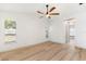 Bright bedroom with hardwood floors featuring a ceiling fan and a view to the home exterior through the windows at 2449 Running Oak Ct, Spring Hill, FL 34608