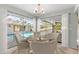 Sunlit dining area with backyard views and a glimpse of the inviting pool through the large windows at 2449 Running Oak Ct, Spring Hill, FL 34608