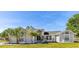 Charming single-story home features a well-manicured lawn, mature trees, and elegant architectural details at 2449 Running Oak Ct, Spring Hill, FL 34608