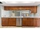 Modern kitchen with stainless steel appliances and bright quartz countertops and wooden cabinetry at 2449 Running Oak Ct, Spring Hill, FL 34608