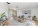 Bright living room featuring stylish furniture, a unique coffee table, and sliding glass doors to the pool at 2449 Running Oak Ct, Spring Hill, FL 34608