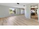 Spacious living room with hardwood flooring, large windows, and an open transition to the kitchen at 2449 Running Oak Ct, Spring Hill, FL 34608