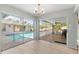 Bright room with hardwood floors offering views of the pool and screened in patio through large glass windows at 2449 Running Oak Ct, Spring Hill, FL 34608