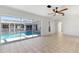 A sunroom features large sliding glass doors opening to a screened-in pool at 2449 Running Oak Ct, Spring Hill, FL 34608