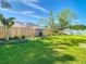 Lush green backyard with wooden fence, showcasing ample space and privacy at 28402 Openfield Loop, Wesley Chapel, FL 33543