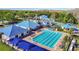 Aerial view of the community pool and recreation area, featuring lap lanes, slides, and a basketball court surrounded by trees at 28402 Openfield Loop, Wesley Chapel, FL 33543
