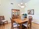 Cozy dining room with hardwood floors, a wooden table and chairs, and elegant chandelier lighting at 28402 Openfield Loop, Wesley Chapel, FL 33543