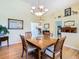 Bright dining room with hardwood floors, a square wooden table, and an elegant chandelier at 28402 Openfield Loop, Wesley Chapel, FL 33543