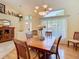 Open dining room showcasing hardwood floors, a chandelier, and a large window with sheer curtains at 28402 Openfield Loop, Wesley Chapel, FL 33543