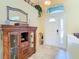 Bright entryway showcasing neutral tile floors, a decorative cabinet, and a white front door with sidelights at 28402 Openfield Loop, Wesley Chapel, FL 33543