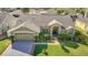 Aerial view of a home featuring a well-kept lawn, mature landscaping, and a charming facade at 28402 Openfield Loop, Wesley Chapel, FL 33543
