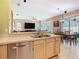 Open concept kitchen with stainless steel dishwasher and tile floors at 28402 Openfield Loop, Wesley Chapel, FL 33543