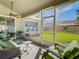 Screened-in lanai with comfortable seating and views of the lush backyard and landscaping at 28402 Openfield Loop, Wesley Chapel, FL 33543