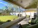Relaxing screened-in lanai with outdoor furniture overlooking the green backyard and white vinyl fence at 28402 Openfield Loop, Wesley Chapel, FL 33543