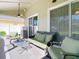Comfortable screened-in lanai with green outdoor furniture and a ceiling fan at 28402 Openfield Loop, Wesley Chapel, FL 33543