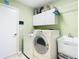 Functional laundry room with modern washer and dryer, sink, white cabinets, and ample storage space at 28402 Openfield Loop, Wesley Chapel, FL 33543